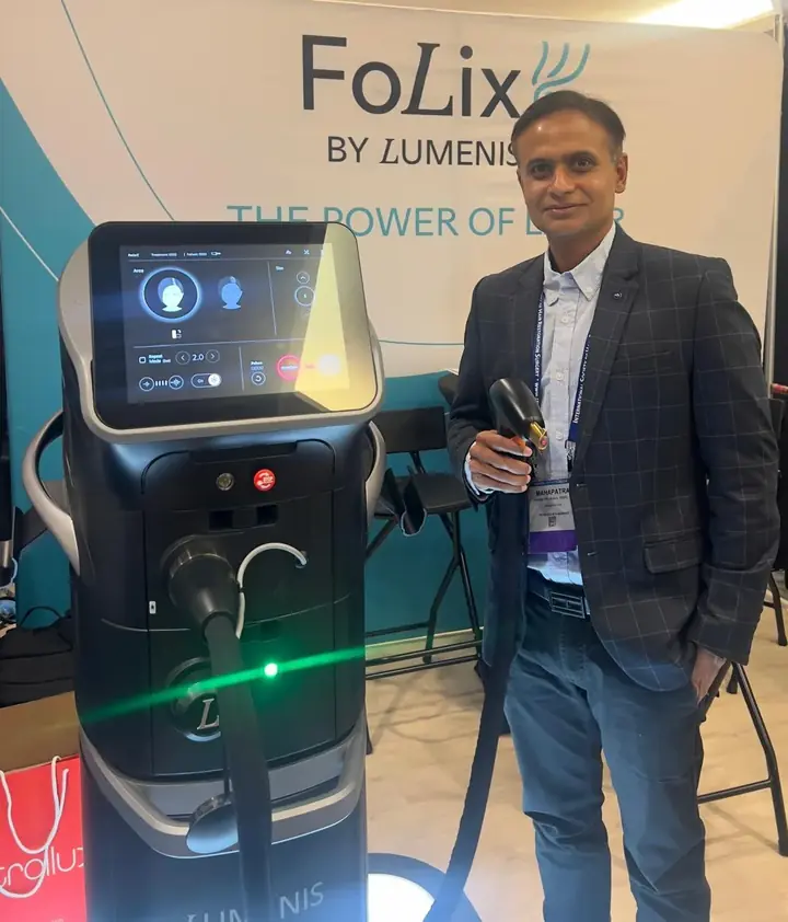 Dr. Sandeep Mahapatra beside a Lumenis FoLix laser device at an international hair restoration conference